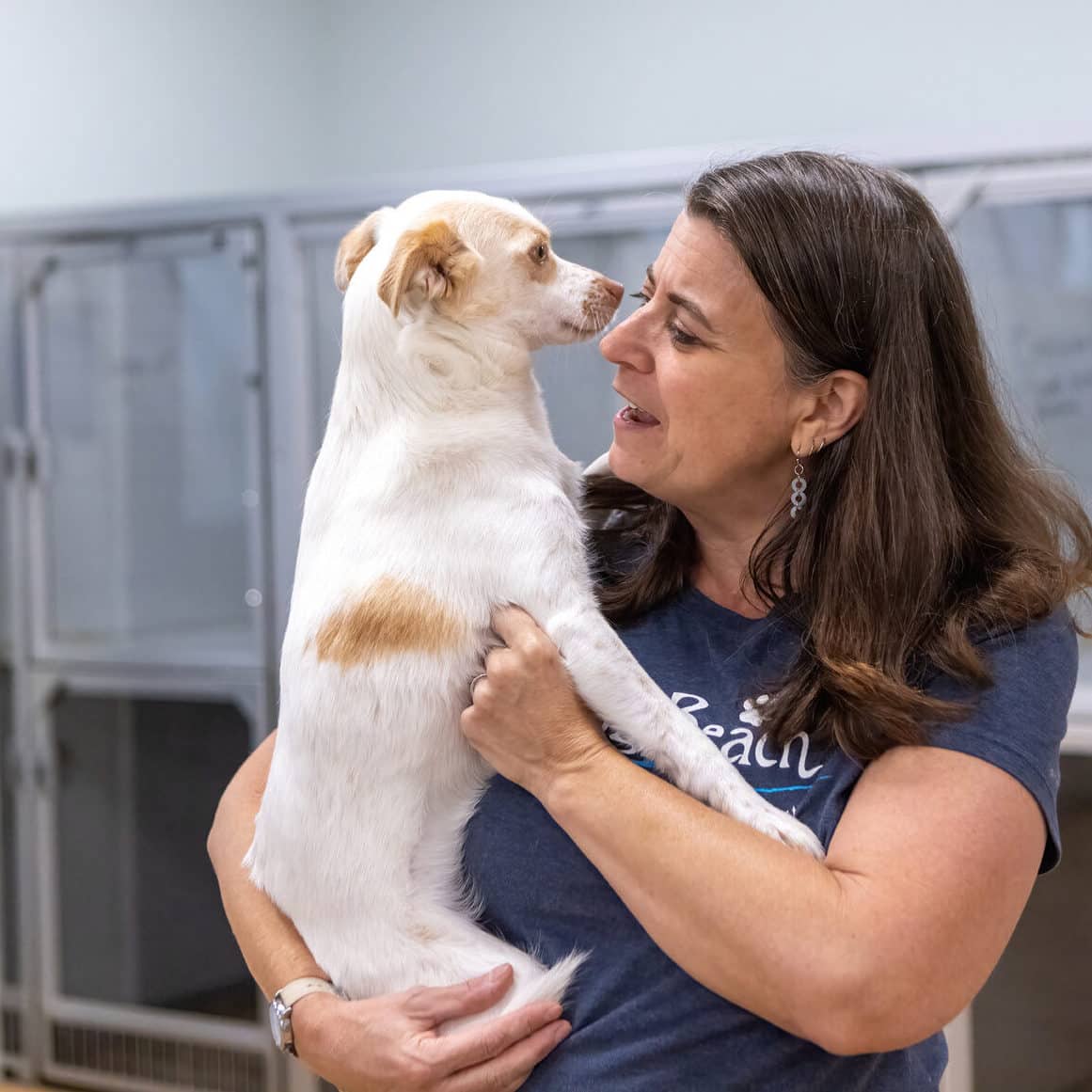 Dog boarding attendant with white Chihuahua at DogBeach Resort & Spa