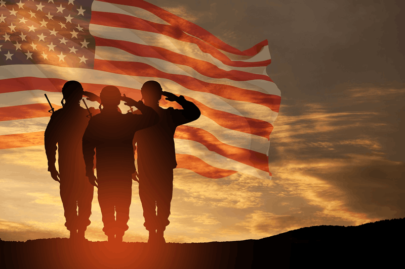 Soldiers in front of American flag and sunset